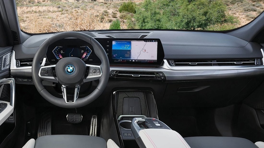 BMW iX2 xDrive30 (2023-…) интерьер, переднее сиденье, водительское сиденье, приборная панель, рулевое колесо, информационно-развлекательная система, кокпит